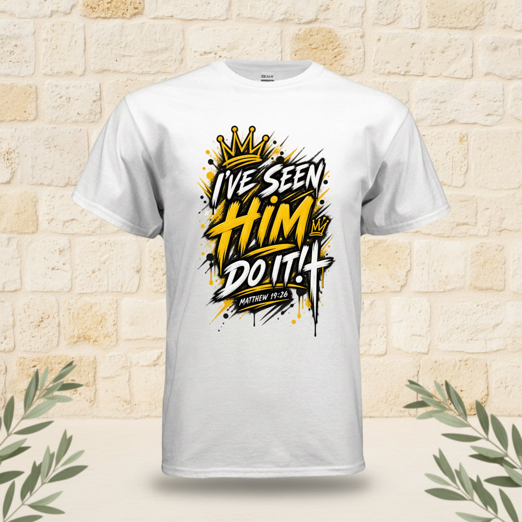 A white short-sleeve crewneck t-shirt featuring a bold graphic on the chest with the text 'I'VE SEEN HIM DO IT!' in yellow, black, and white graffiti-style lettering, complete with a gold crown illustration at the top.