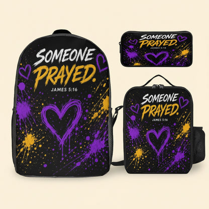 A black backpack shown with two smaller matching pouches on a plain white background. The backpack and pouches feature the phrase “SOMEONE PRAYED.