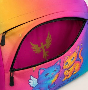 Kids backpack close-up: magenta zipper pocket with gold wing emblem and cat print