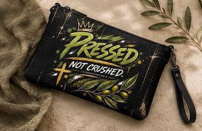 Black crossbody bag with 'PRESSED NOT CRUSHED' front graphic, zip top and wrist strap