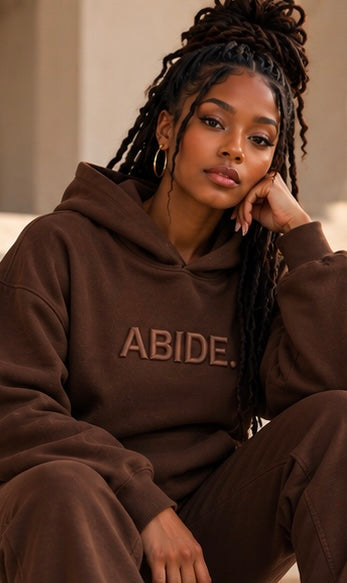 Brown ABIDE hoodie with hood and front kangaroo pocket, model wearing