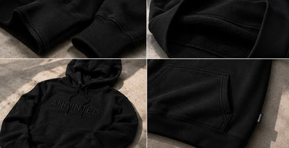 A black pullover hoodie shown in a four-panel collage, highlighting the ribbed cuffs, soft fleece lining, front kangaroo pocket, and tonal embroidered 'ANOINTED' logo on the chest.