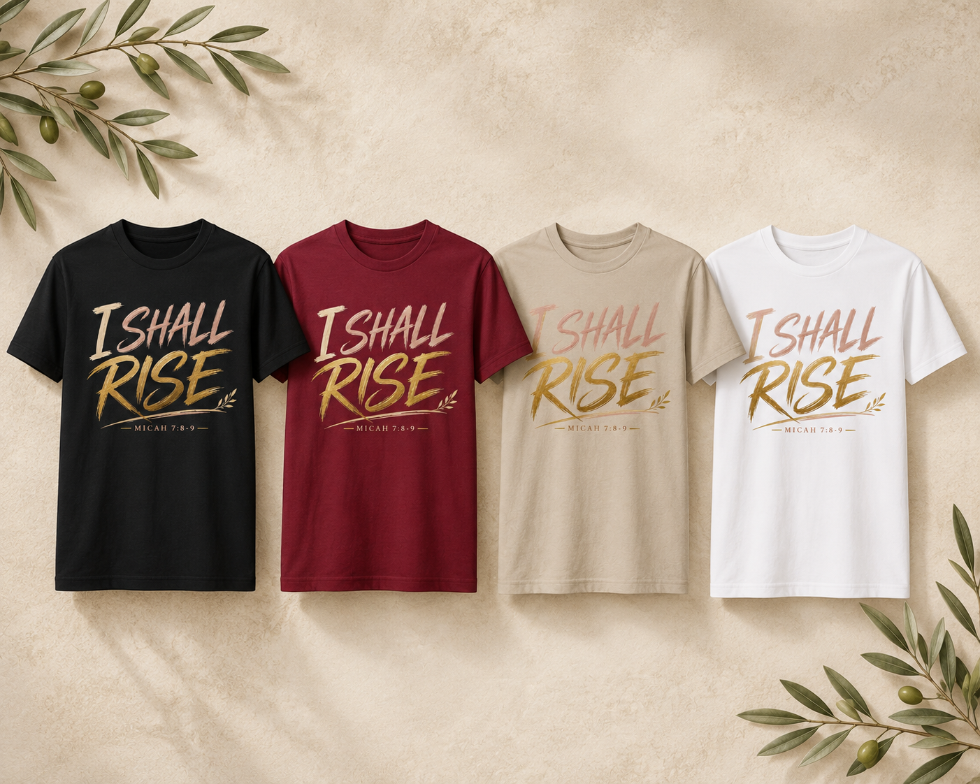 Four graphic T-shirts in black, burgundy, beige, and white, arranged side by side on a textured beige background with decorative olive branches in the corners. Each shirt features the words 'I SHALL RISE' in a metallic gold font with a small olive branch graphic and 'MERCED TO GOD' underneath.