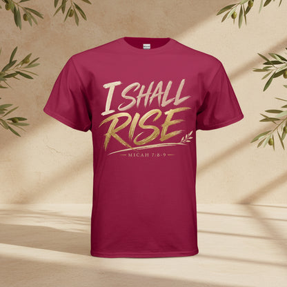 A maroon short-sleeve t-shirt with a graphic on the chest reading 'I SHALL RISE' in white and gold lettering, with 'MICAH 7:8-9' printed below, shown on a plain white background.
