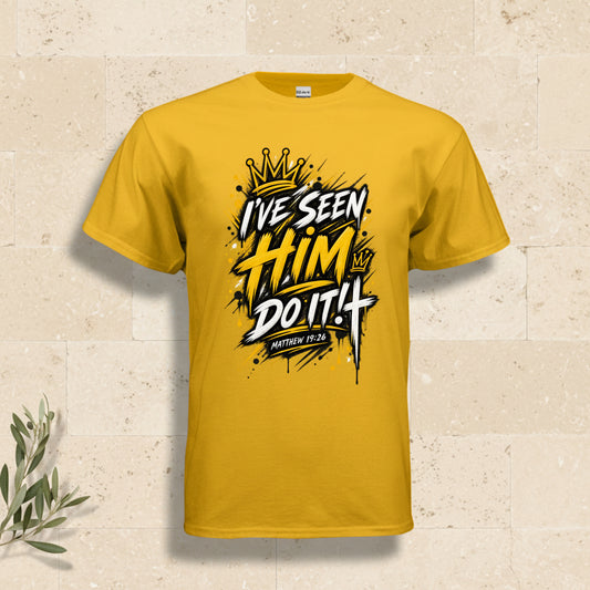 A yellow short-sleeve crewneck t-shirt with a bold graphic on the chest reading 'I'VE SEEN HIM DO IT! MATTHEW 11:4' in stylized black, white, and yellow lettering with a gold crown illustration.